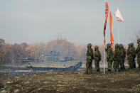 Members of Japanese Ground-Self Defense Force (JGDDF) watch as a Type 90 tank maneuvers through a course during an annual exercise at the Minami Eniwa Camp Tuesday, Dec. 7, 2021, in Eniwa, Japan's northern island of Hokkaido. Dozens of tanks are rolling over the next two weeks on Hokkaido, a main military stronghold for a country with perhaps the world's most little known yet powerful army. (AP Photo/Eugene Hoshiko)