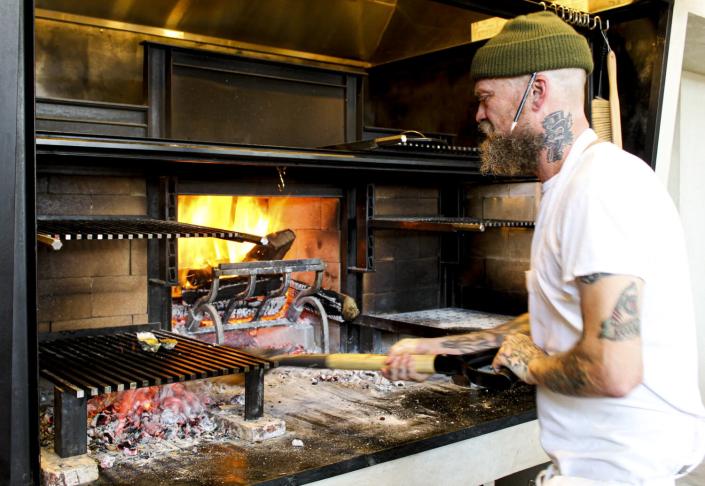 Chef Brian Dunsmoor takes care of his restaurant's hearth oven.