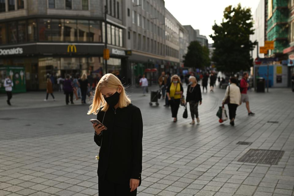 People walk through Liverpool city centre as new local restrictions are confirmed (AFP via Getty Images)