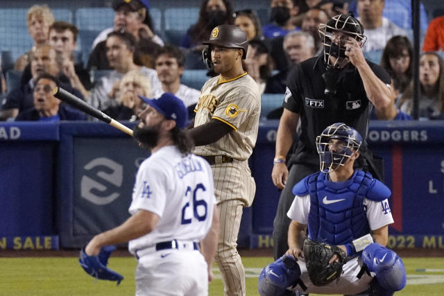 San Diego Padres' Trent Grisham, second from left, watches the ball go along with Los Angeles Dodgers starting pitcher Tony Gonsolin, left, catcher Austin Barnes, right, and home plate umpire Scott Barry after hitting a solo home run during the fifth inning of a baseball game Friday, July 1, 2022, in Los Angeles. (AP Photo/Mark J. Terrill)