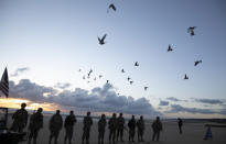 Men in a vintage US WWII uniform watch as pigeons are released during a D-Day 76th anniversary ceremony in Saint Laurent sur Mer, Normandy, France, Saturday, June 6, 2020. Due to coronavirus measures many ceremonies and memorials have been cancelled in the region with the exception of very small gatherings. (AP Photo/Virginia Mayo)