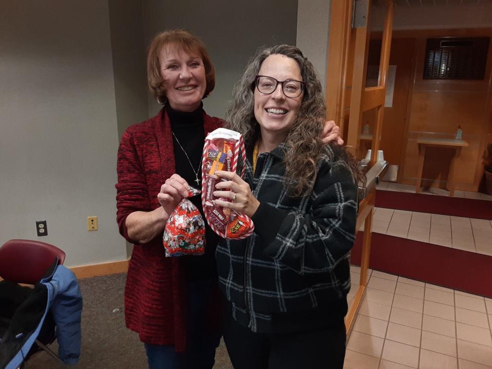 Judith Watkins (left), coordinator of the Helping Hands Ministry at Community Lutheran Church in Flat Rock, and Rev. Amy Treibwasser, pastor of the Flat Rock United Methodist Church, hold up candy and a stocking stuffer that will be included in a food distribution to the needy Wednesday at the Lutheran church.