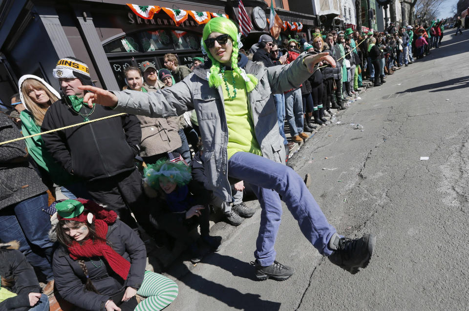 Marin Marx, of Paris, dances in the street during the annual St. Patrick's Day parade in the South Boston neighborhood of Boston, Sunday, March 16, 2014. (AP Photo/Michael Dwyer)