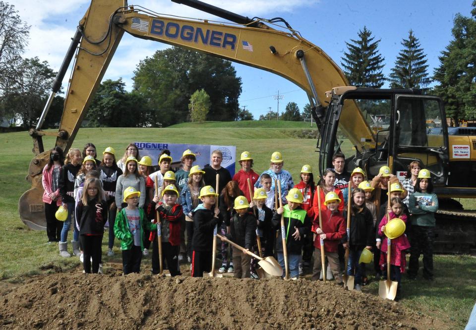 School children in Rittman help shovel ground Friday at the site where a new Wayne County Public Library branch will be constructed.
