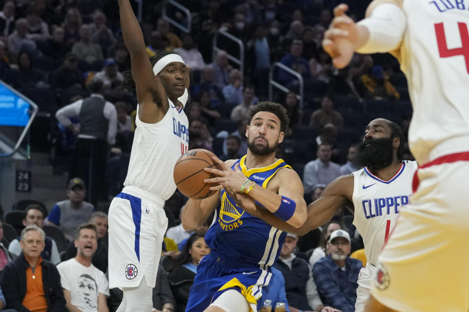 Los Angeles Clippers guard James Harden (1) pokes the ball away from Golden State Warriors guard Klay Thompson, center, during the first half of an NBA basketball game Thursday, Nov. 30, 2023, in San Francisco. (AP Photo/Godofredo A. Vásquez)