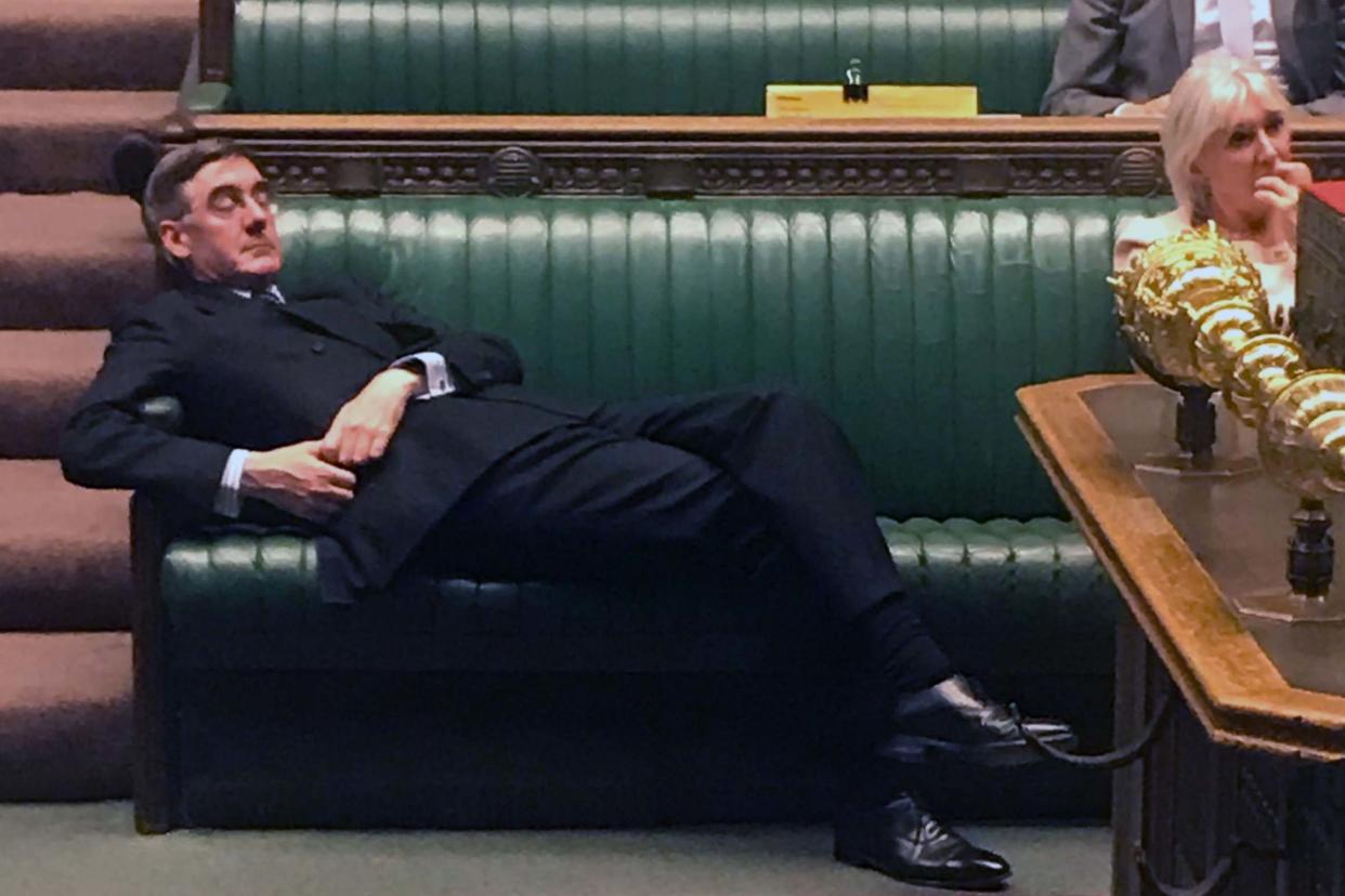 Flat out: Jacob Rees-Mogg lies back on the green benches of the House during the debate over the Commons timetable: AFP/Getty Images