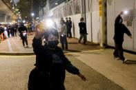 Supporters of pro-democracy activists wave flashlights as a prison van which is carrying some of 47 pro-democracy activists charged with national security law leaves West Kowloon Magistrates' Courts, in Hong Kong