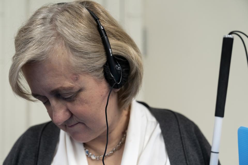 Patti Chang, who is blind, uses headphones and audio along with an electronic controller outfitted with braille to vote in the Chicago mayoral runoff election at the Roden Branch of the Chicago Public Library, Wednesday, March 22, 2023, in Chicago. Like many voters with disabilities, Chang faces barriers at the polls most voters never even consider — missing ramps or door knobs, for example. The lack of help or empathy from some poll workers just adds to the burden for people with disabilities. (AP Photo Erin Hooley)