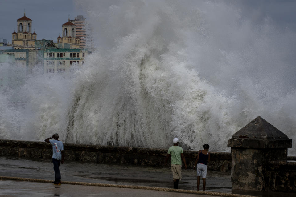 FILE - People stand along a waterfront as huge waves crash against a seawall in the wake of Hurricane Ian in Havana, Cuba, Wednesday, Sept. 28, 2022. National Oceanic and Atmospheric Administration on Thursday, May 25, 2023, announced its forecast for the 2023 hurricane season. (AP Photo/Ramon Espinosa, File)