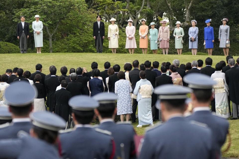 Japan's Emperor Naruhito, left, Empress Masako, second left, and other royal family members walk down a hill to greet guests during the spring garden party at the Akasaka Palace imperial garden Tuesday, April 23, 2024, in Tokyo. (AP Photo/Eugene Hoshiko)