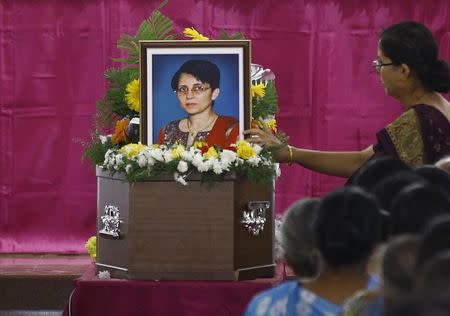 A woman puts flowers on Jacintha Saldanha's coffin during her funeral inside a church in Shirva, about 52 km (32 miles) north of Mangalore December 17, 2012. REUTERS/Stringer/Files