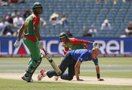 England's bowler Stuart Broad (C) gets up off the pitch after attempting to field a ball as Bangladesh's batsmen Mohammad Mahmudullah (L) and Soumya Sarkar make runs during their Cricket World Cup match in Adelaide, March 9, 2015. REUTERS/David Gray