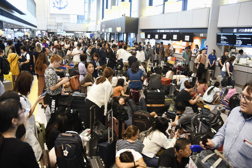 Travelers are stranded at Narita airport in Narita, near Tokyo Monday, Sept. 9, 2019 as railways and subway operators suspended services following a typhoon. Typhoon Faxai blew across the Tokyo metropolitan area Monday morning, causing dozens of injuries, while disrupting rush-hour travel and knocking out power. (Kyodo News via AP)