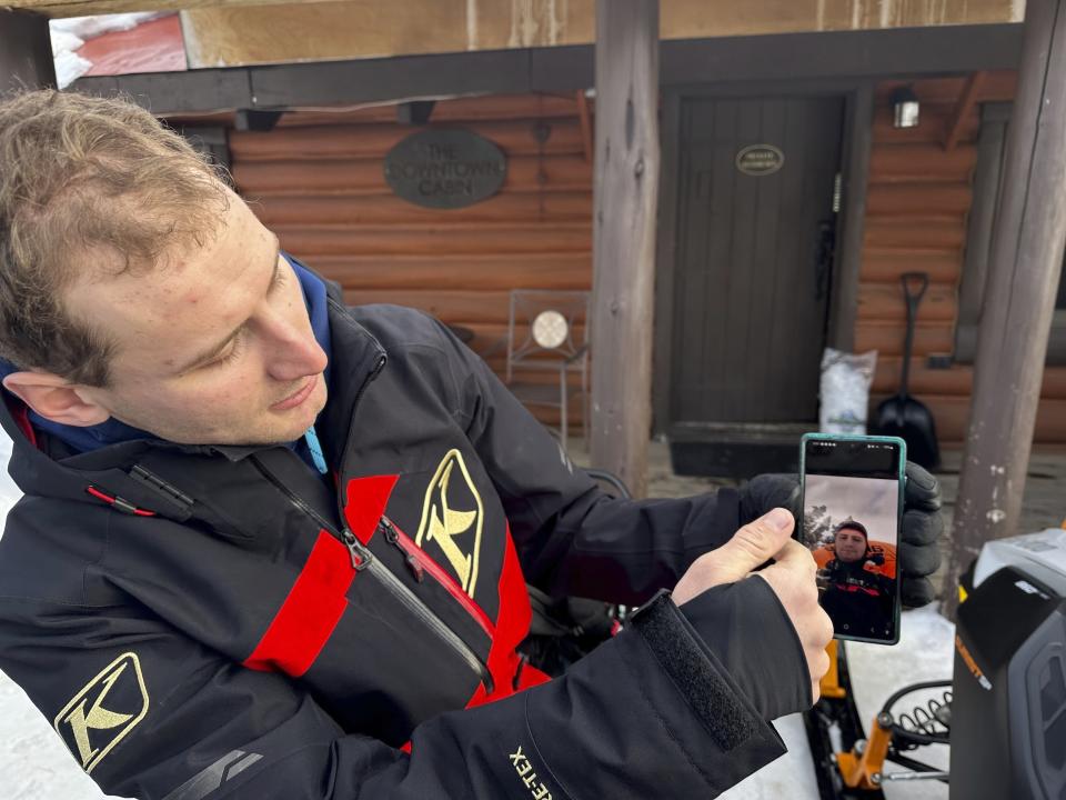 Wesley Mlaskoch describes deploying an airbag after he was caught in an avalanche in the backcountry in the Gallatin National Forest, Jan. 29, 2024, near Cooke City, Mont. The avalanche flipped Mlaskoch's snowmobile on top of him. (AP Photo/Matthew Brown)