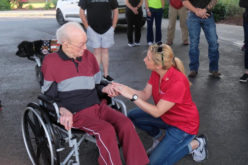 A representative of Xcel Energy gives World War II veteran Cleatus Lebow a coin to honor his service at a ceremony for the USS Indianapolis survivor held Monday at the Ussery-Roan Texas State Veterans Home in Amarillo.