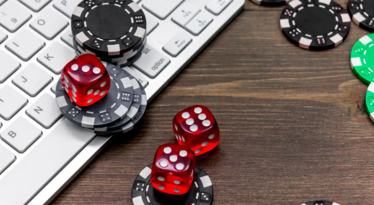 poker chips and dice on top of a keyboard representing gambling stocks