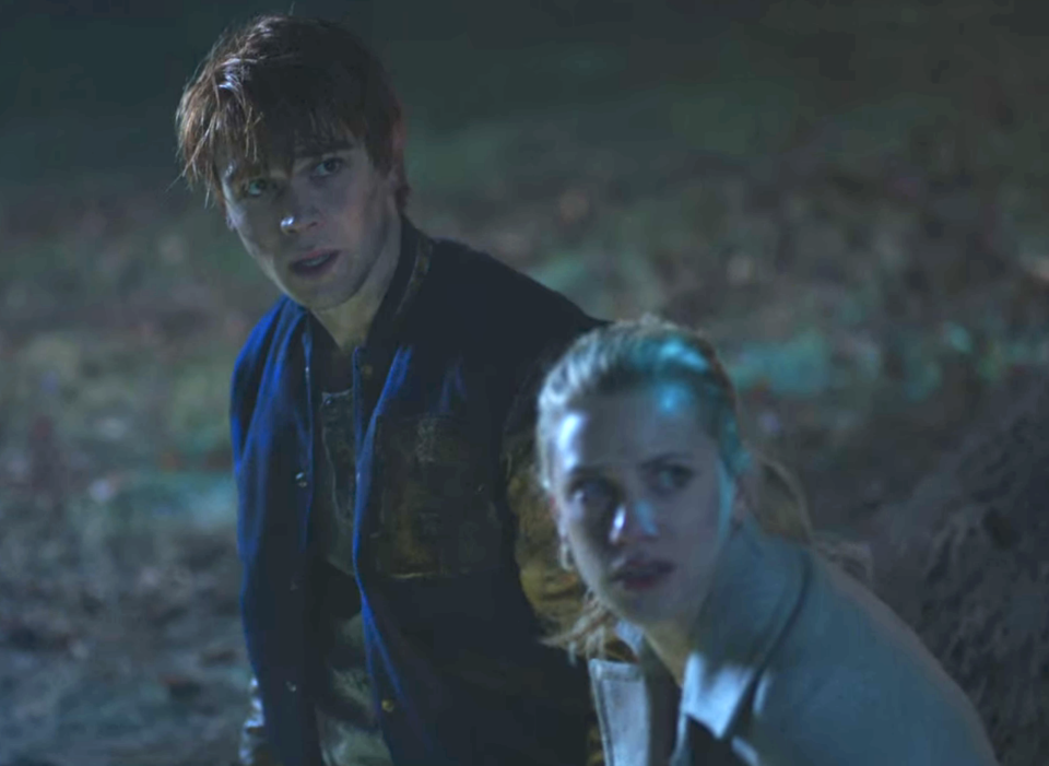 a young guy and woman looking up at something outside in the dark with scared expressions