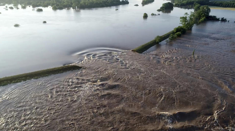 In this aerial image provided by Yell County Sheriff's Department water rushes through the levee along the Arkansas River Friday, May 31, 2019, in Dardanelle, Ark. Officials say the levee breached early Friday at Dardanelle, about 60 miles northwest of Little Rock. (Yell County Sheriff's Department via AP)