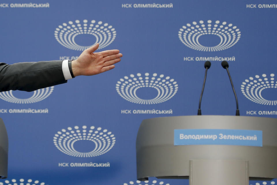 Ukrainian President Petro Poroshenko gestures toward a tribune with Volodymyr Zelenskiy's name written on it, as he answers a journalist's question ahead of the presidential elections on April 21, at the Olympic stadium in Kiev, Ukraine, Sunday, April 14, 2019. Zelenskiy, who's never held office, challenged Poroshenko to take part in a debate in the stadium two days before the election, but Poroshenko wanted it to be held Sunday. (AP Photo/Efrem Lukatsky)