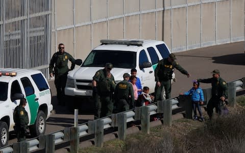 U.S. Border Patrol agents after crossing illegally over the border wall into San Diego, California - Credit: &nbsp;Rebecca Blackwell/AP