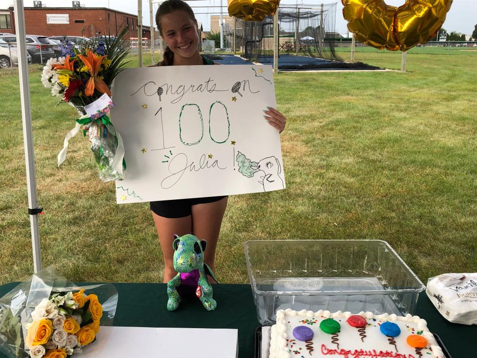 Richwoods High School senior tennis player Julia Wojtowicz received a sign, cake, flowers and balloons from her coaches, teammates and family, all gathered to celebrate her 100th varsity match win on Saturday, Sept. 16, 2023 at Richwoods' tennis courts.