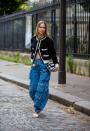 <p>Give baggy denim a posh treatment with a French-style cardigan and white heels. </p>