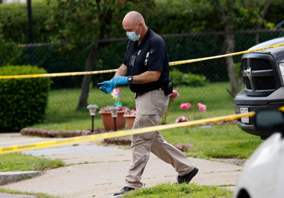 An investigator walks out of a home along Broadway Street, in Newton, Mass, on Sunday. (AP)