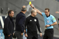 Referee Sascha Stegemann, right, shows Munich coach Hansi Flick, left, the yellow card during the German Bundesliga soccer match between Eintracht Frankfurt and Bayern Munich in Frankfurt, Germany, Saturday, Feb. 20, 2021. (Arne Dedert/POOL via AP)