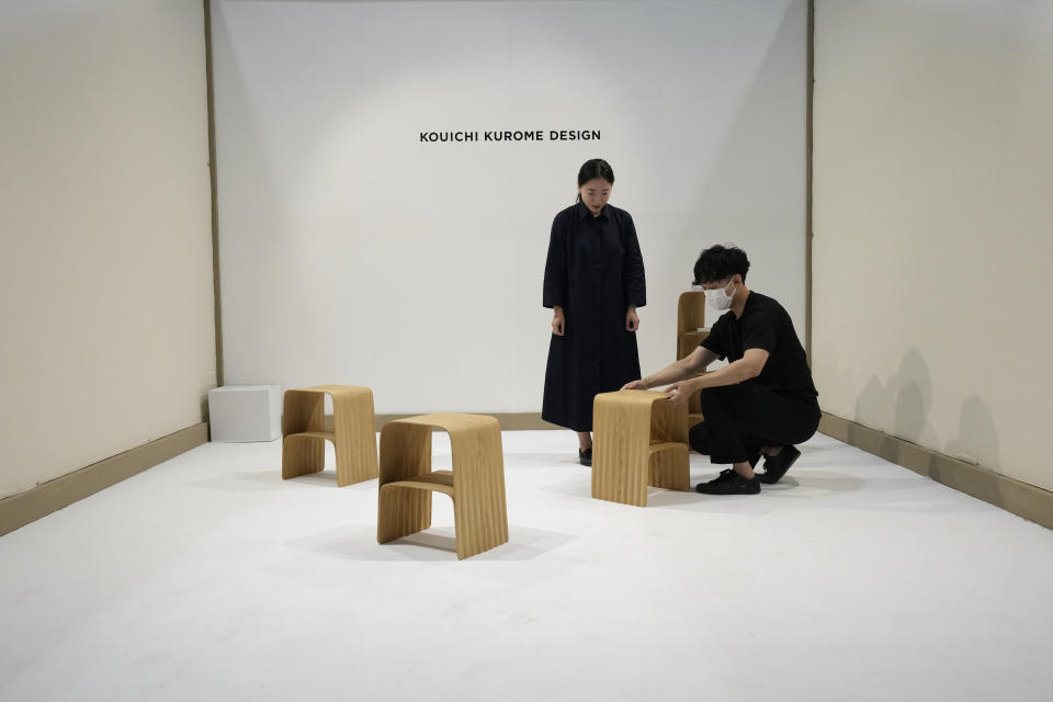 People look at creations by Kouichi Kurome's furniture designers, part of the Design Fair exhibition in Milan, Italy, Tuesday, June 7, 2022. (AP Photo/Antonio Calanni)