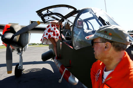 A hostess of the Bronco demo team boards an OV-10 Bronco aircraft, decorated with World War One commemoration motifs, at Flanders international airport, ahead of the world's first Short Take Off & Landing competition on sand, in Wevelgem, Belgium May 8, 2018. REUTERS/Francois Lenoir