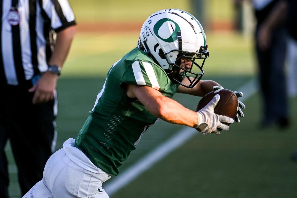 Olivet's Ramsey Bousseau catches a pass on the sideline against Charlotte during the first quarter on Friday, Aug. 26, 2022, at Olivet High School.