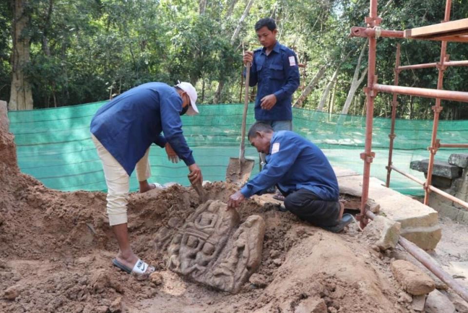 Workers in the process of removing a statue from the ground