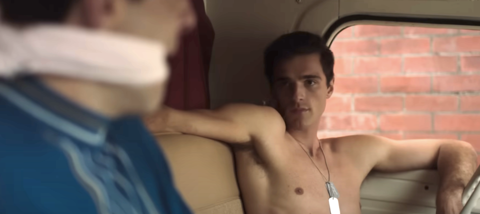 jacob's character is shirtless in a car sitting next to someone he's gagged