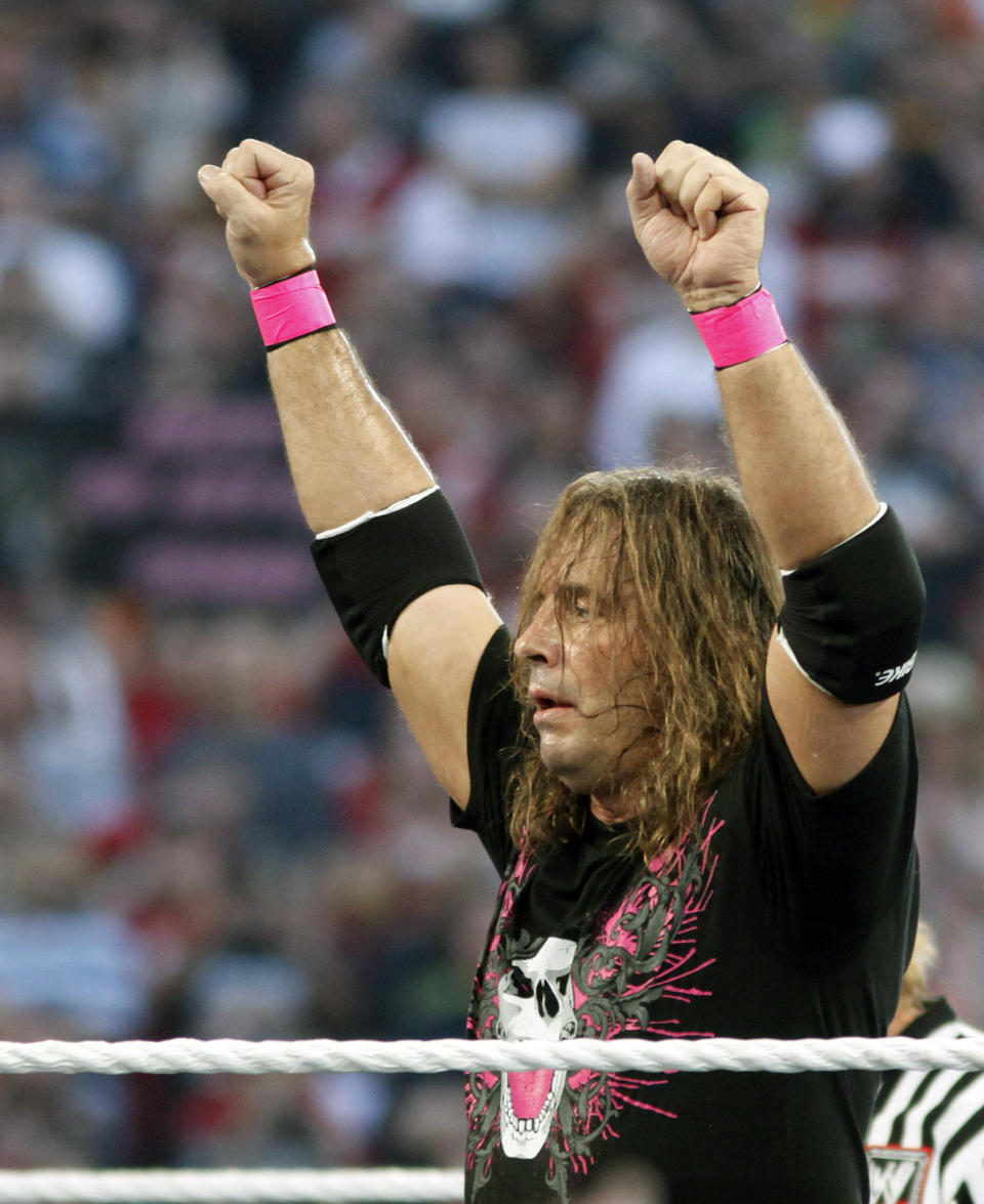 FILE - In this March 28, 2010, file photo, Bret "Hit Man" Hart celebrates his victory over Mr. McMahon at WrestleMania XXVI in Glendale, Ariz. Hart was tackled by a spectator Saturday, April 6, 2019, while he was giving a speech during the WWE Hall of Fame ceremony at Barclays Center. The attacker was promptly subdued by several people, including other wrestlers, who came to Hart’s defense. Hart is okay. (AP Photo/Rick Scuteri, File)