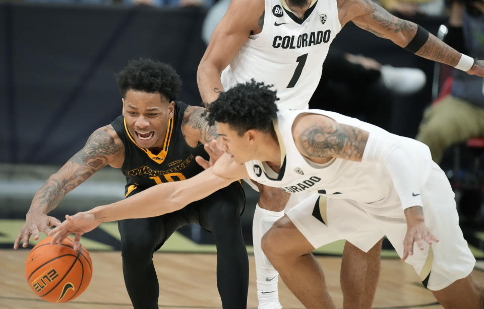 Milwaukee guard BJ Freeman, left, competes for control of the ball with Colorado guard KJ Simpson during the second half of an NCAA college basketball game Tuesday, Nov. 14, 2023, in Boulder, Colo. (AP Photo/David Zalubowski)