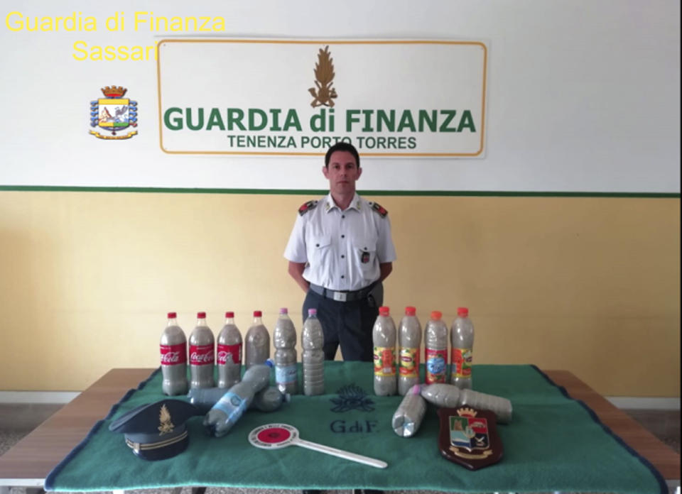 This picture taken on Aug. 16, 2019 and made available Tuesday, Aug. 20, 2019 by the Finance Police of the Sardinian port of Porto Torres, Italy, shows 14 plastic bottles of sand seized from a French couple in the trunk of the couple’s car. The French couple could face up to six years in jail for taking around 40 kg (88.1lbs) of the island's famed white sand from Chia beach, which is protected as a public good. (Italian Finance Police via AP)