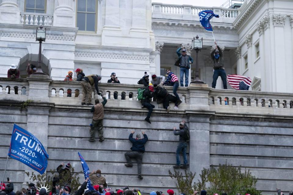 Supporters of President Donald Trump climb the west wall of the the U.S. Capitol on Wednesday, Jan. 6, 2021, in Washington. (AP Photo/Jose Luis Magana)