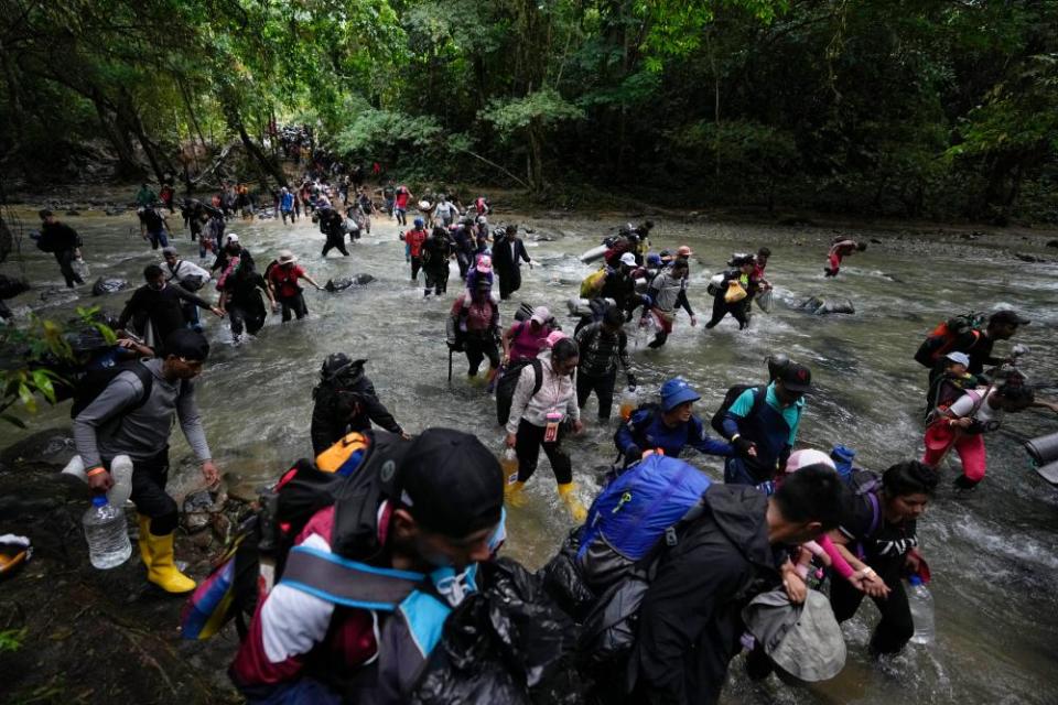Migrants, mostly Venezuelans, cross a river during their journey through the Darién Gap in October 2022.
