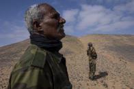 Polisario Front soldiers look at a Minurso helicopter, not pictured, near Mehaires, Western Sahara, Thursday, Oct. 14, 2021. Drawing attention to a conflict with few known casualties in a vast but forgotten corner of the Sahara desert has been a challenge for the Polisario, whose leaders want to leverage the guerrilla-war-reminiscent imagery ahead of a key U.N. meeting on Oct. 28. Security Council members are due to vote on extending the mission for the Minurso, the force that for years, and at a cost of over $4 billion, has overseen the ceasefire while supposedly paving the way for a referendum. (AP Photo/Bernat Armangue)