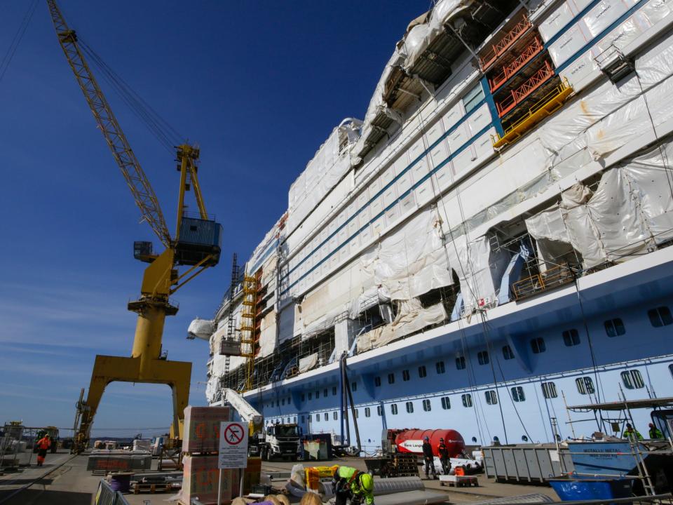 Royal Caribbean's Icon of the Seas cruise ship under construction. There's people walking around and a crane.