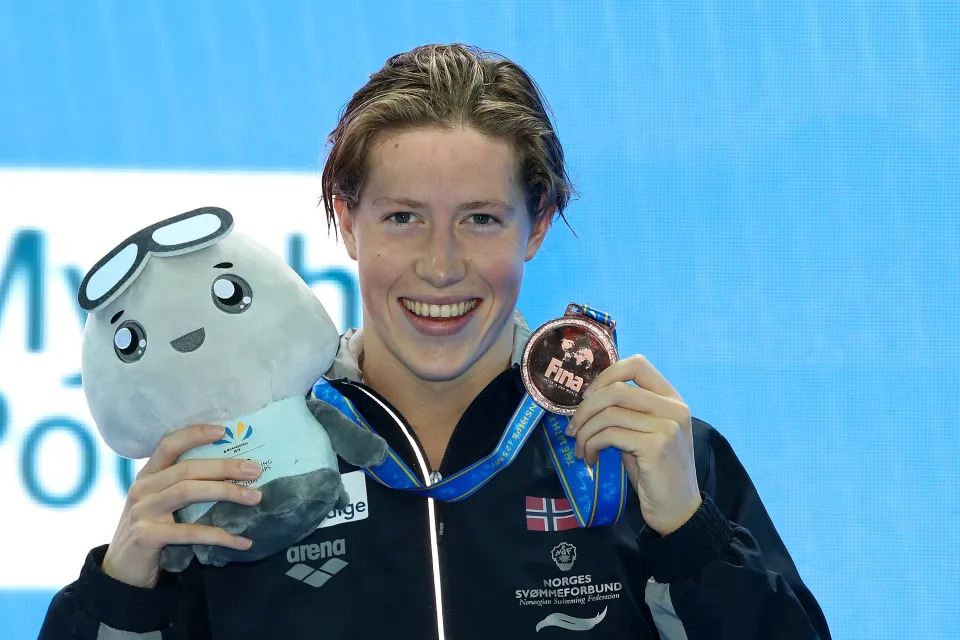 Bronze medalist Henrik Christiansen of Norway poses, holding up his medal.