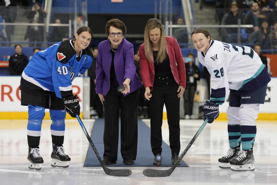 PWHL board member Billie Jean King, center left, and PWHL executive Jayna Hefford drop pucks between Toronto captain Blayre Turnbull, left, and New York captain Micah Zandee-Hart (right) for the ceremonial faceoff before the inaugural PWHL hockey game in Toronto on Monday, Jan.1, 2024. (Frank Gunn