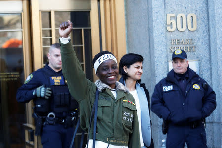Therese Patricia Okoumou raises her fist after her sentencing for conviction on attempted scaling of the Statue of Liberty to protest the U.S. immigration policy, outside a federal court in New York, U.S., March 19, 2019. REUTERS/Shannon Stapleton