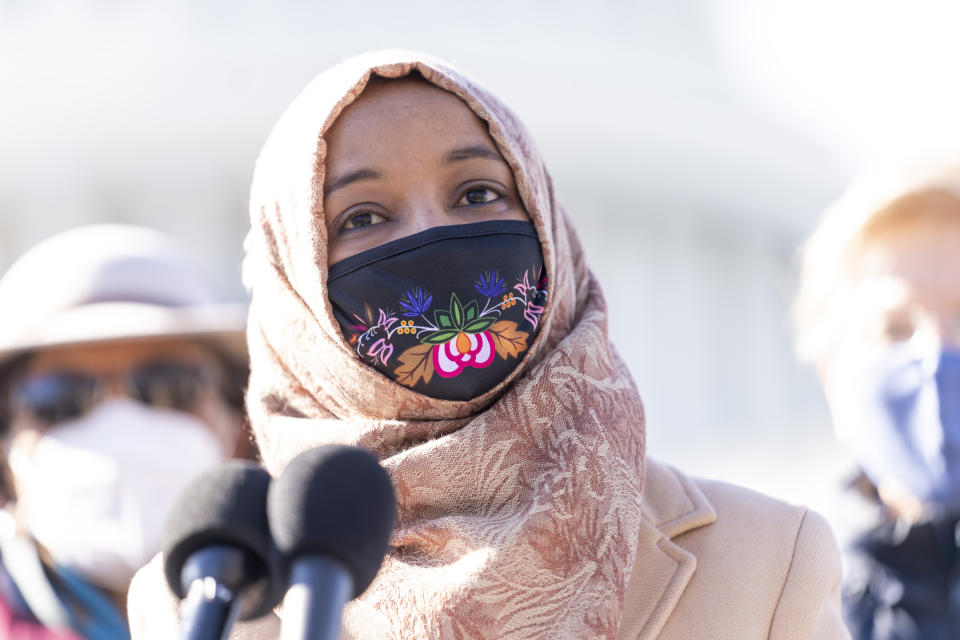 Rep. Ilhan Omar, D-Minn., center, accompanied by Sen. Elizabeth Warren, D-Mass., right, and Rep. Alma Adams, D-N.C., left, speaks at a news conference on Capitol Hill in Washington, Thursday, Feb. 4, 2021, about plans to reintroduce a resolution to call on President Biden to take executive action to cancel up to $50,000 in debt for federal student loan borrowers. (AP Photo/Andrew Harnik)