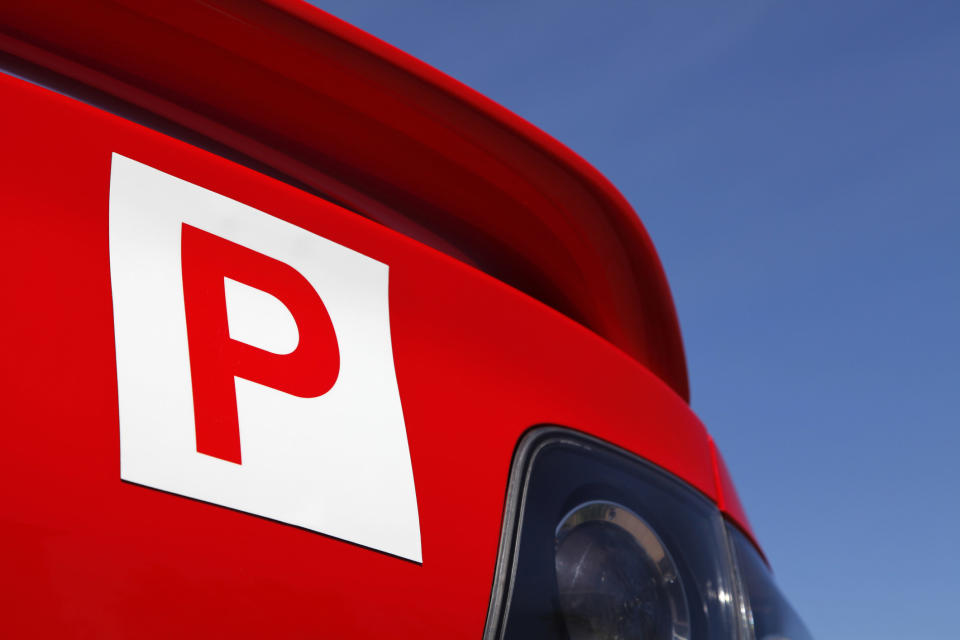 A red P plate stuck on the back of a car