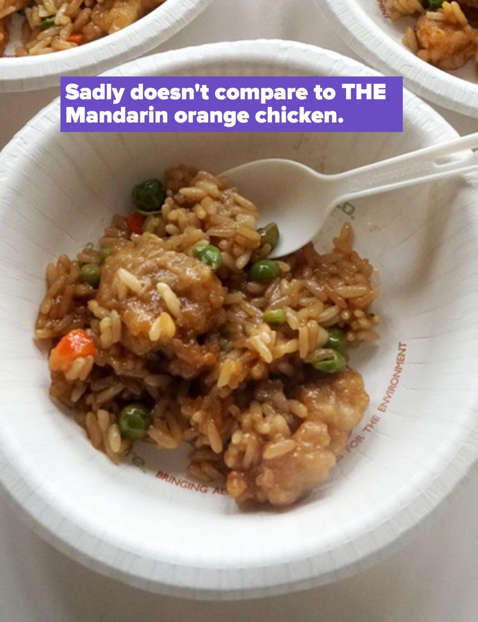 A close-up of Mandarin-style orange chicken over fried rice with vegetables