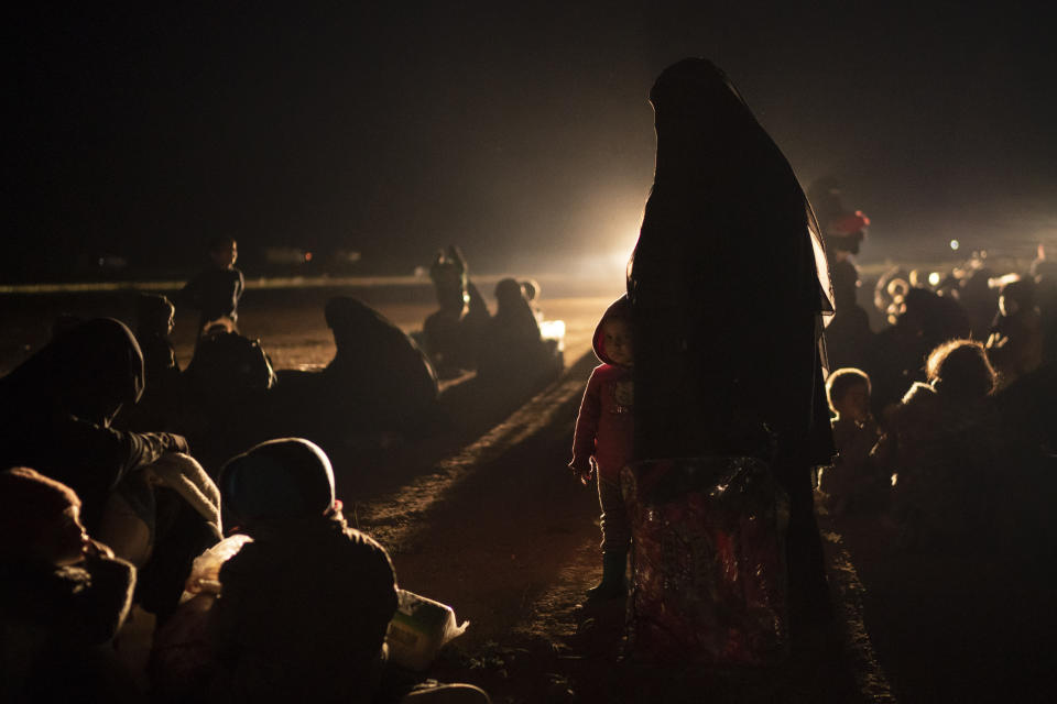 Women and children evacuated out of the last territory held by Islamic State militants wait after being screened by U.S.-backed Syrian Democratic Forces (SDF) in the desert outside Baghouz, Syria, Monday, Feb. 25, 2019. (AP Photo/Felipe Dana)