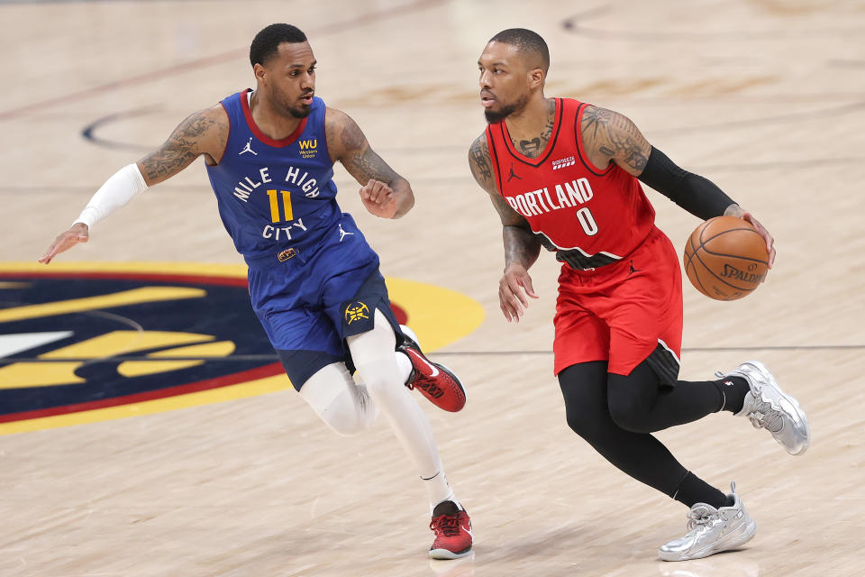 DENVER, COLORADO - MAY 22: Damian Lillard #0 of the Portland Trail Blazers brings the ball down the court against Monte Morris #11 of the Denver Nuggets in the fourth quarter during Game One of their Western Conference first-round playoff series at Ball Arena on May 22, 2021 in Denver, Colorado. NOTE TO USER: User expressly acknowledges and agrees that, by downloading and or using this photograph, User is consenting to the terms and conditions of the Getty Images License Agreement. (Photo by Matthew Stockman/Getty Images)