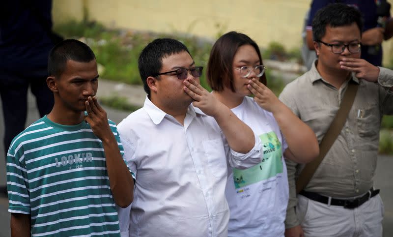 Protest leaders arrive to report themselves at a police station in Bangkok