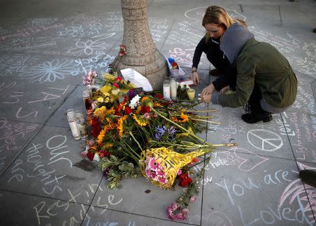 Students light candles at a tribute for victims, at one of nine crime scenes after a series of drive-by shootings that left 7 people dead, in the Isla Vista neighborhood of Santa Barbara, California May 26, 2014. REUTERS/Lucy Nicholson